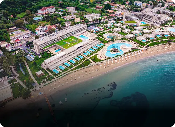 Aerial view of a luxury beachfront resort with swimming pools and sandy shore along the turquoise Mediterranean coast in Antalya Turkey